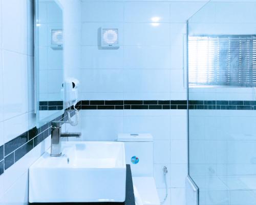 La salle de bains est pourvue de toilettes, d'un lavabo et d'une douche. dans l'établissement No.8 Boutique Hotel, à Ilorin