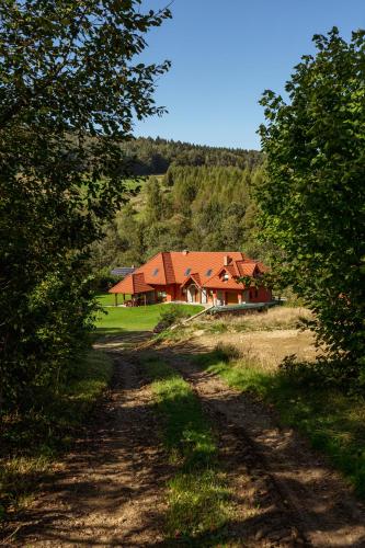 a house in the middle of a dirt road at Siedlisko Leszczyny in Kunkowa