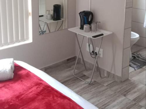 a bedroom with a bed and a table and a mirror at Hopslot Villa in Mossel Bay