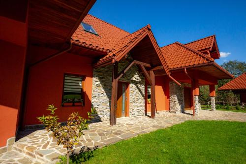 una casa roja con techo rojo y patio en Siedlisko Leszczyny en Kunkowa