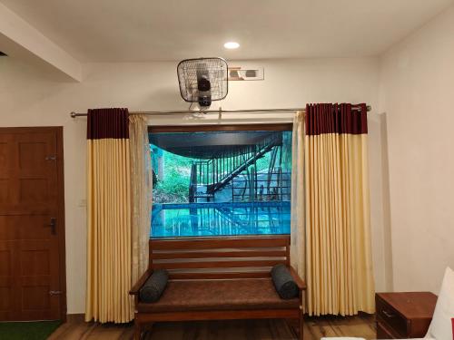 a window with a bench in a room at Agasthya Private Pool & Park villa in Sultan Bathery
