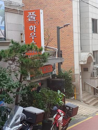 um sinal para um restaurante com uma moto estacionada lá fora em Full house em Seul