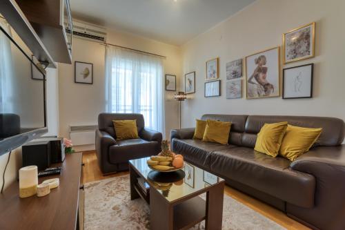 uma sala de estar com um sofá e uma mesa em Gold apartman em Podgorica