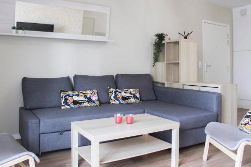 ein Wohnzimmer mit einem blauen Sofa und einem Tisch in der Unterkunft Large cosy nest with balcony in Aubervilliers in Aubervilliers