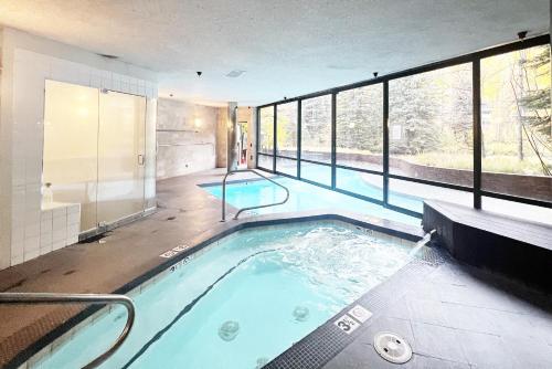 a swimming pool in a building with a large group of windows at Ice House 317 condo in Telluride