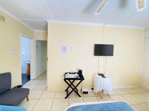 una sala de estar con un sofá y una mesa en The Valley Guest House, en Pietermaritzburg