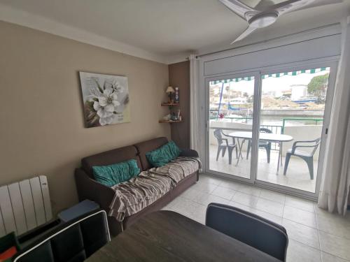 uma sala de estar com um sofá, uma mesa e uma varanda em Appartement avec Piscine et Vue Canaux em Roses