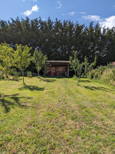 a house in a field with trees in the background at Shirehill Farm, Shires Barns in Chippenham