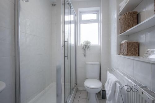 a white bathroom with a toilet and a shower at Sea Breeze Apt 2 - 2 Bedroom - Horton Beach in Horton