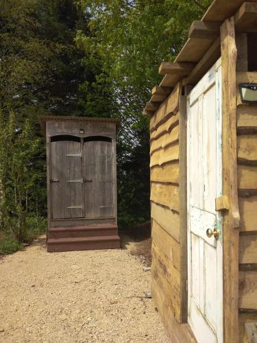 a wooden shed with a door next to it at Shirehill Farm, Shires Barns in Chippenham