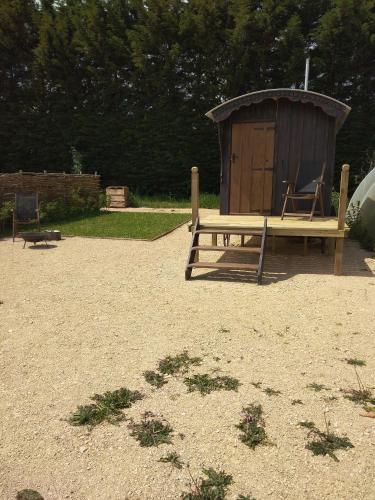 un parque infantil con un banco de madera y una cabaña de madera en Shirehill Farm, Shires Barns, en Chippenham