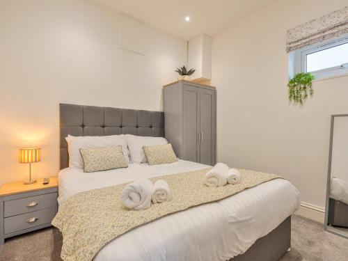 una camera da letto con un grande letto con asciugamani di Pass the Keys Modern Apartment With Courtyard a Madeley