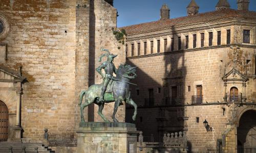 a statue of a man riding a horse in front of a building at Izan Trujillo in Trujillo