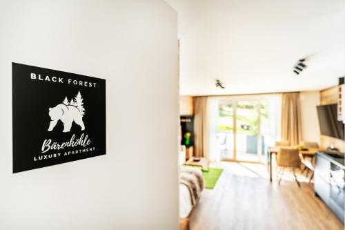 ein Wohnzimmer mit einem schwarzen Waldschild an der Tür in der Unterkunft Black Forest Luxury Apartment Bärenhöhle mit Sauna in Schluchsee