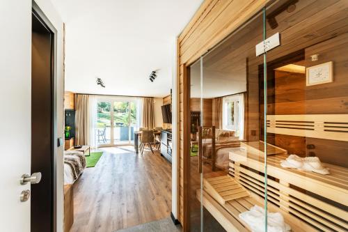 Pokój z drewnianymi ścianami i szklanymi drzwiami w obiekcie Black Forest Luxury Apartment Bärenhöhle mit Sauna w mieście Schluchsee