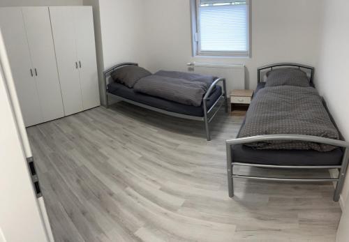 2 camas en una habitación con suelo de madera en AlWi Appartements, en Moringen