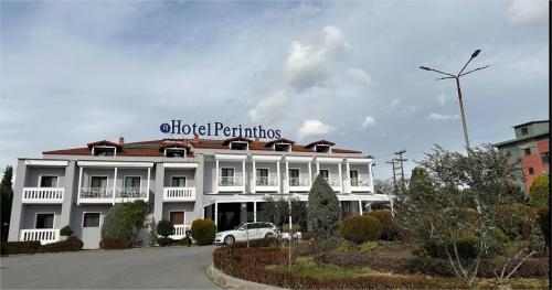 a white building with a sign on top of it at Perinthos Hotel in Anchialos