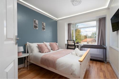 um quarto com uma cama grande e uma janela em Chique Manchester Abode - Parking - 8mins to City em Manchester