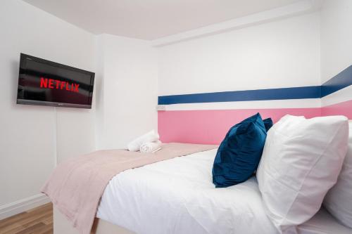 a bedroom with a bed with a tv on the wall at Chique Manchester Abode - Parking - 8mins to City in Manchester