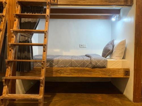 a bunk bed in a room with a ladder at Vin vin in Ubud