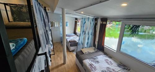 Habitación pequeña con cama y ventana en Hideout Hostel en Haad Rin