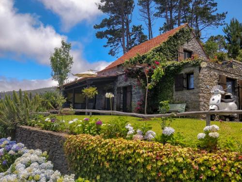 a house with flowers in front of it at Achadinha - Mountain Cottage in Arco da Calheta