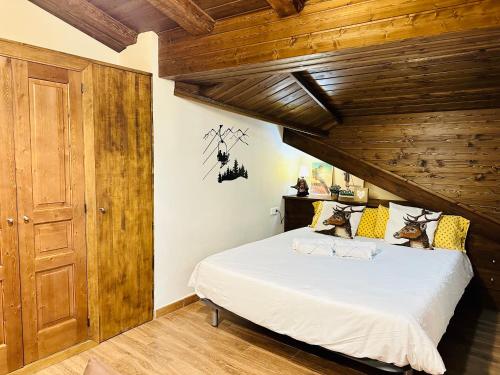 a bedroom with a large bed with a wooden ceiling at Apartament Immovall in Durro