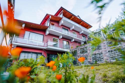 ジョシマットにあるAaryam Resort, Auliの目の前にオレンジの花が咲く赤い建物