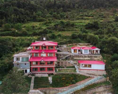 a house on a hill with red roofs at Aaryam Resort, Auli in Joshīmath