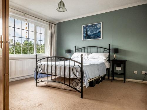 1 dormitorio con cama y pared verde en Pass the Keys Bright, comfortable 3 bed home with garden & parking, en Ottery St Mary