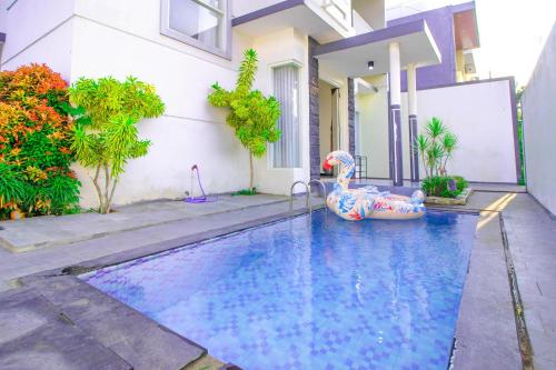 an outdoor swimming pool with an inflatable pool noodle in a house at Villa Azzalia Syariah Private Pool and Karaoke in Tlekung