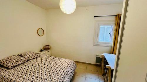 une chambre avec un lit, un bureau et une fenêtre dans l'établissement T2 Sète proche centre ville, à Sète