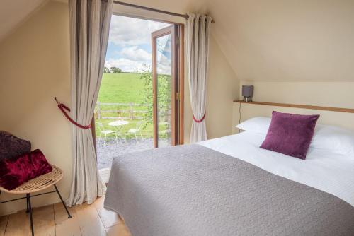 a bedroom with a bed and a large window at Little Wren in Holbeton