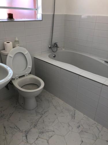ein Badezimmer mit einem WC, einer Badewanne und einem Waschbecken in der Unterkunft Bluebanana Lodge in Mthatha