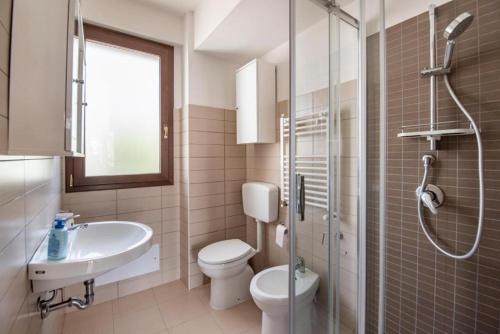 a bathroom with a toilet and a sink and a shower at Villa Donata Fontane Bianche in Fontane Bianche