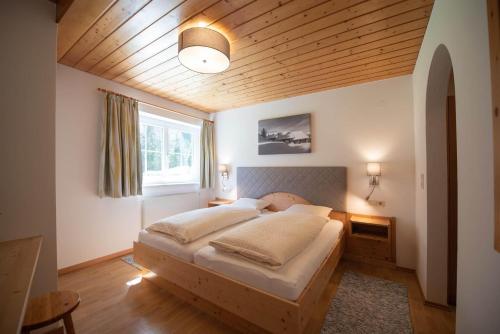 a bedroom with a large bed with a wooden ceiling at Ferienwohnung Carbonare in Sankt Gallenkirch