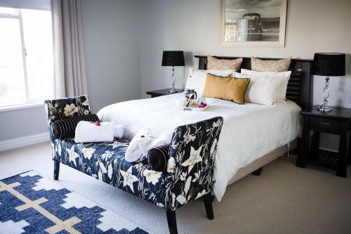 a bedroom with a large bed and a chair at Doran Vineyards in Paarl