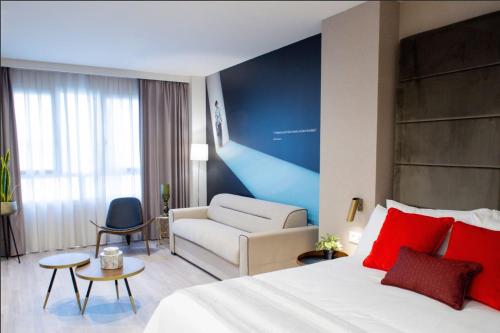 een hotelkamer met een bed en een bank bij Voghe Premium Flats in Valencia