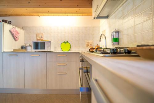 a kitchen with white cabinets and a microwave at Villa Donata Fontane Bianche in Fontane Bianche