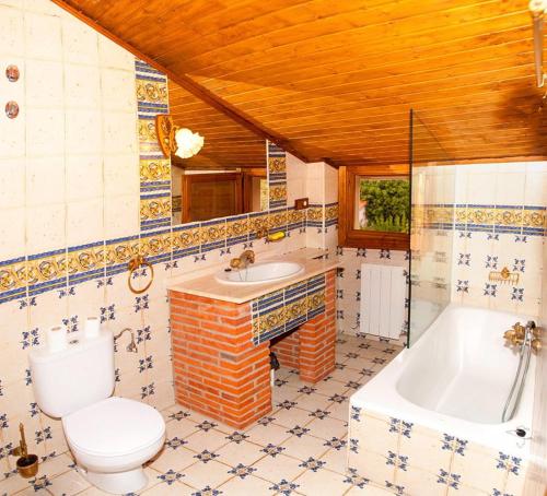 a bathroom with a toilet and a tub and a sink at Alojamiento Rural Villanueva del Conde in Villanueva del Conde