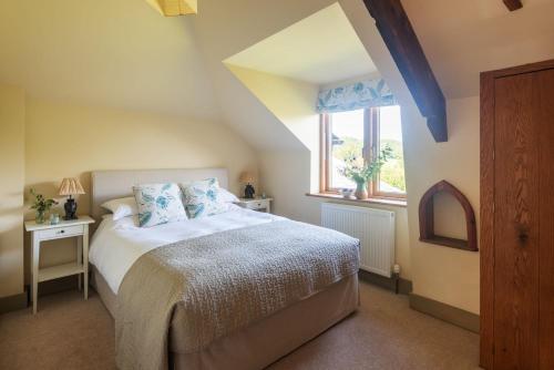 a bedroom with a bed and a window at Otter's Cottage in Holbeton