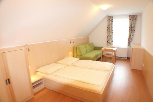 ザンクト・ギルゲンにあるユーウントゲストハウス ザンクト ギルゲンのベッドルーム1室(ベッド1台、緑の椅子付)
