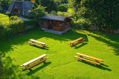 a group of benches sitting in the grass in front of a cabin at Jugendgästehaus St. Gilgen in Sankt Gilgen