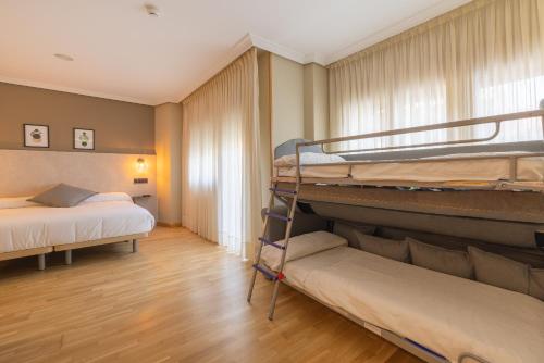 um quarto com 2 beliches e uma janela em Hotel Santamaria em Tudela