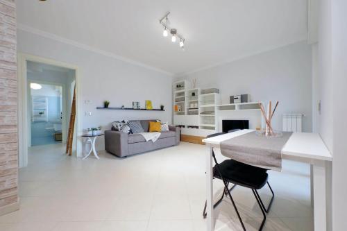 a white living room with a couch and a table at Lusso Con Vista - Elegante e Luminoso con Self Check-in, Vicino All'Aeroporto in Fiumicino