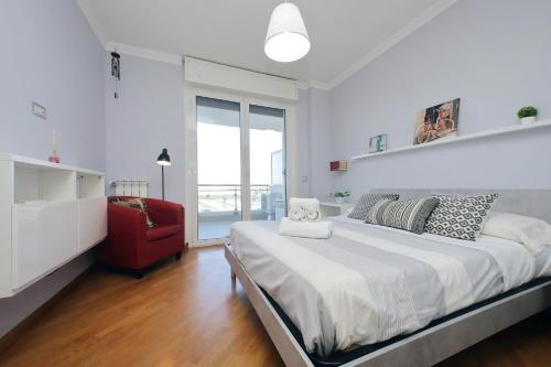 una camera da letto con un letto grande e una sedia rossa di Bilocale con vista sull'aeroporto - comodo per il viaggio a Fiumicino