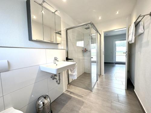 a white bathroom with a sink and a shower at alte Scheune Drolshagen in Drolshagen