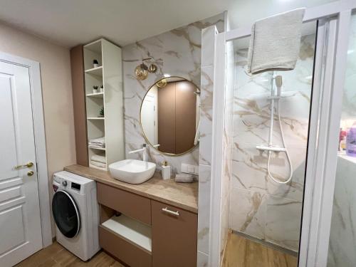 ein Bad mit einem Waschbecken und einem Spiegel in der Unterkunft Naujas 2 kambarių butas in Vilnius