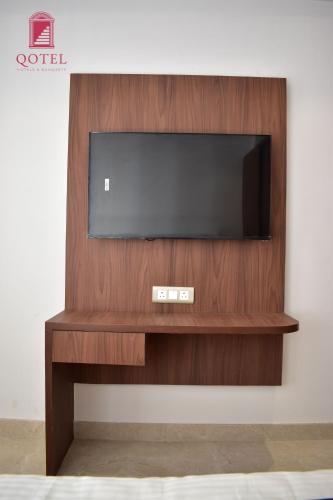 a entertainment center with a flat screen tv on a wall at Qotel Hotel Signature BNB-Ashok Vihar in New Delhi