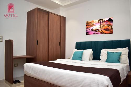 a bedroom with a large bed with a wooden cabinet at Qotel Hotel Signature BNB-Ashok Vihar in New Delhi